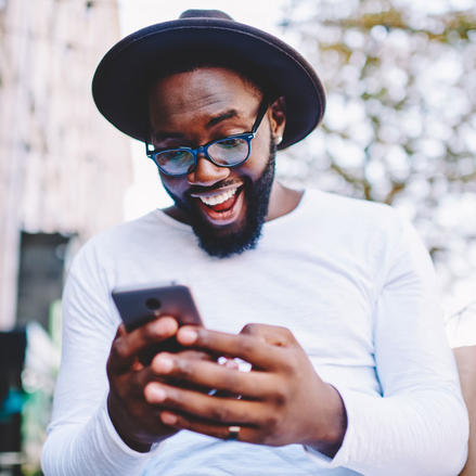 A customer looks happily at his smartphone.